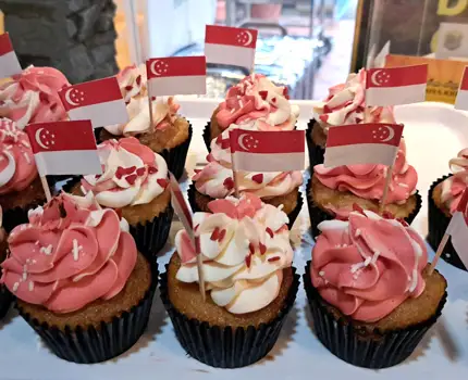 Mini cupcakes with red and white frosting and Singapore flags, perfect for buffet catering singapore. 